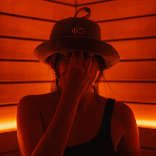 Una clienta amb un barret de sauna d'ILO STUDIOS a la sauna